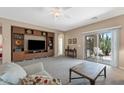 Bright and airy living room with built-in shelving, access to the backyard patio, and neutral carpet at 799 W Press Rd, San Tan Valley, AZ 85140