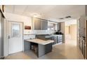 Neutral kitchen design with white backsplash, gray cabinets, and a unique peninsula at 9347 E Edgewood Ave, Mesa, AZ 85208
