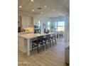 Open kitchen with white cabinets, island with seating and a dining area with large windows at 1185 E Gleneagle Dr, Chandler, AZ 85249