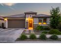 Charming home exterior with a well-manicured landscape, a welcoming front door, and warm exterior lighting at 22849 E Marsh Rd, Queen Creek, AZ 85142