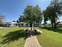 A tree stands in the middle of a well-maintained lawn, leading to a charming home with a white facade at 2311 E Colter St, Phoenix, AZ 85016