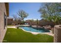 Beautiful backyard pool with rock features, turf and desert landscaping at 3549 W Magellan Dr, Anthem, AZ 85086