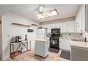 Bright kitchen with white cabinets, tile floors, a skylight, and modern appliances at 4501 E Carol Ave # 48, Mesa, AZ 85206