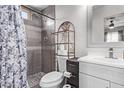 Cozy bathroom featuring a tiled shower, decorative shelving, and a white vanity at 7357 W Cheryl Dr, Peoria, AZ 85345