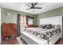 Well lit bedroom featuring a ceiling fan, queen size bed, and an antique dresser at 7357 W Cheryl Dr, Peoria, AZ 85345
