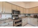 Close-up of kitchen featuring stone countertops and stainless steel appliances at 13616 N 102Nd Pl, Scottsdale, AZ 85260