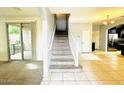 Open-concept living area with staircase, tile and carpet flooring, and sliding door access at 17749 W Woodrow Ln, Surprise, AZ 85388