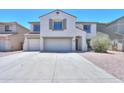 Inviting two-story home featuring a three-car garage, desert landscaping, and a neutral color palette at 43601 W Cowpath Rd, Maricopa, AZ 85138