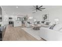 Bright living room features sleek ceiling fan, wood floors, and stylish white furniture at 8522 E Virginia Ave, Scottsdale, AZ 85257
