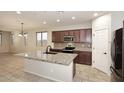 Bright kitchen featuring dark wood cabinets, granite countertops, stainless steel appliances, and a large island at 10065 E Tiger Lily Ave, Mesa, AZ 85212