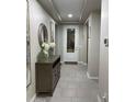 Elegant hallway with ceramic floors, console table, decorative mirror, and light-filled entryway at 11562 W Levi Dr, Avondale, AZ 85323