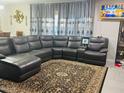 Spacious living room featuring a dark leather sectional sofa and decorative rug at 11562 W Levi Dr, Avondale, AZ 85323