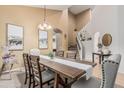 Open-concept dining room features a stylish table and chairs with a view of the staircase and second floor at 12376 W Hazelwood St, Avondale, AZ 85392