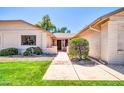 Inviting front entrance with a well-manicured lawn and mature landscaping leading to a warm and welcoming front door at 14151 W Yosemite Dr, Sun City West, AZ 85375