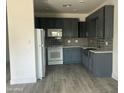 Kitchen featuring gray cabinets, stainless steel appliances, tile backsplash and wood-look tile flooring at 1519 N Etta St, Casa Grande, AZ 85122