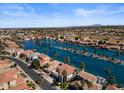 Wide aerial view of a waterfront community with a lake, houses, and palm trees on a sunny day at 1539 W Laurel Ave, Gilbert, AZ 85233