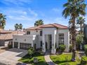 Well-manicured front exterior of a modern white home with a tile roof, green lawn and palm trees at 1539 W Laurel Ave, Gilbert, AZ 85233