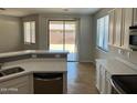 Bright open-concept kitchen with stainless appliances, quartz counters, tile flooring, and backyard access at 15461 W Jefferson St, Goodyear, AZ 85338