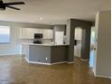 Open concept kitchen featuring white cabinets, light countertops, and stainless steel appliances at 15461 W Jefferson St, Goodyear, AZ 85338