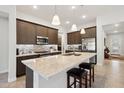 Modern kitchen with granite countertops, stainless steel appliances, and dark wood cabinetry at 16946 W Vernon Ave, Goodyear, AZ 85395