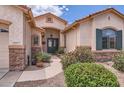 Charming home entrance with a walkway and mature desert landscaping at 17951 W Sammy Way, Surprise, AZ 85374