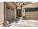 Inviting front entry with a two-car garage, a single-car garage, and manicured landscaping at 18970 W Desert Hills Dr, Surprise, AZ 85388