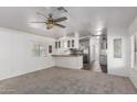 Living room showing neutral carpet, light walls, and view of the kitchen at 201 S Greenfield Rd # 129, Mesa, AZ 85206