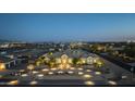 Aerial shot showcases the estate, including a circular driveway, mature landscaping, and beautiful night-time lighting at 20213 W Amelia Ave, Buckeye, AZ 85396