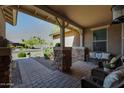 Inviting covered front porch with stone accents and comfortable seating area at 20959 W Western Dr, Buckeye, AZ 85396