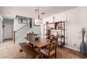Cozy dining room featuring a wooden table set, decorative shelving, and a staircase leading to the upper level at 2435 N Riley Rd, Buckeye, AZ 85396