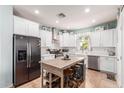 Spacious kitchen with white cabinets, stainless steel appliances, kitchen island and a view to the backyard at 2435 N Riley Rd, Buckeye, AZ 85396