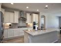 Modern kitchen featuring stainless steel appliances, granite countertops, and white cabinetry at 26421 W Zachary Dr, Buckeye, AZ 85396