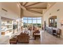 Spacious living room featuring a curved window wall and an inviting fireplace at 29308 N 108Th N Pl, Scottsdale, AZ 85262