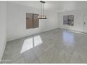 Dining room with tile flooring, a modern light fixture, and bright windows at 30271 W Crittenden Ln, Buckeye, AZ 85396