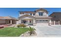 Charming two-story home featuring lush landscaping and a two car garage with a classic desert color palette at 7670 W Sands Dr, Peoria, AZ 85383