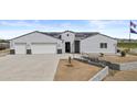 Attractive ranch home boasts a three-car garage, manicured lawn, and contemporary design with solar panels at 8429 S 229Th Ln, Buckeye, AZ 85326