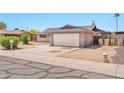 Exterior shows the garage of a charming home with desert landscaping and a well-maintained driveway at 9102 N 56Th Ln, Glendale, AZ 85302