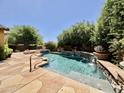 Sparkling pool featuring stone waterfall feature and a beautiful, landscaped backyard at 9249 E Desert Arroyos St, Scottsdale, AZ 85255