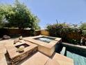 An in-ground spa with stone trim sits near a pool with water feature in a landscaped backyard at 9249 E Desert Arroyos St, Scottsdale, AZ 85255