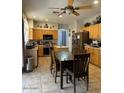 Eat-in kitchen featuring stainless appliances, wooden cabinets, and tile floors at 135 N 119Th Dr, Avondale, AZ 85323