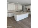 Bright kitchen featuring white cabinets, a center island, and stainless steel faucet at 2467 W Rowel Rd, Phoenix, AZ 85085