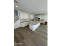 Open kitchen showcasing white cabinets, an island, and wood-style floors at 2467 W Rowel Rd, Phoenix, AZ 85085