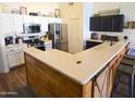 Eat-in kitchen with stainless steel appliances, white cabinetry, and a peninsula with seating at 520 E Appaloosa Rd, Gilbert, AZ 85296