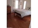 Bright bedroom with wood floors, a dresser, and soft floral bedding at 14566 N 90Th Ln, Peoria, AZ 85381