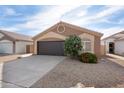 Lovely single-story home with a two-car garage, desert landscaping, and an arched window at 14566 N 90Th Ln, Peoria, AZ 85381