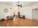 Open-concept living room with wood floors, vaulted ceiling, and neutral wall color at 14566 N 90Th Ln, Peoria, AZ 85381