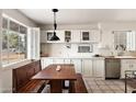 Bright kitchen featuring custom cabinets, a built-in dining nook, and a view to the neighborhood beyond at 2205 W Gardenia Dr, Phoenix, AZ 85021