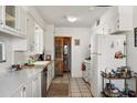 Well-lit kitchen with tile flooring, white appliances, and access to the pantry/wine cellar at 2205 W Gardenia Dr, Phoenix, AZ 85021