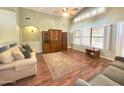Bright living room boasts wood floors, high ceilings, large windows, ceiling fan and custom built-ins at 2453 E Nathan Way, Chandler, AZ 85225
