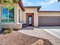 Charming front entrance with brick walkway, stone accents, and a cozy seating area at 29363 N 132Nd Ln, Peoria, AZ 85383